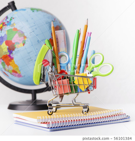 World globe and shopping cart with stationery on white World globe and shopping cart with stationery on white 56101384