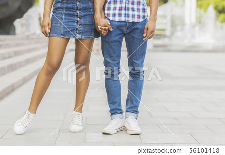 Romantic couple holding hands while walking in the city Romantic couple holding hands while walking in the city 56101418