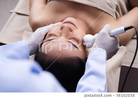 woman receiving ultrasound facial beauty treatment woman receiving ultrasound facial beauty treatment 56102038