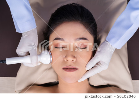 woman receiving ultrasound facial beauty treatment woman receiving ultrasound facial beauty treatment 56102046