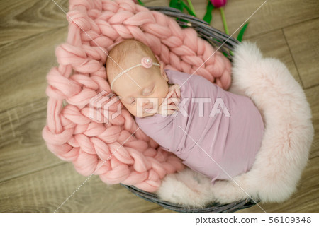 newborn baby girl in pink blanket in a basket newborn baby girl in pink blanket in a basket 56109348