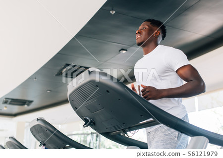 Sportsman working out on training machine 56121979