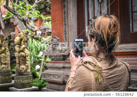 Woman takes picture with a smartphone 56128642