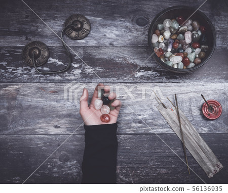 Hand holding small stones in energy healing  56136935