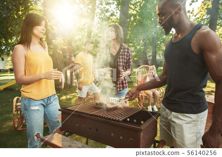 Happy friends are having beer and barbecue party at sunny day 56140256