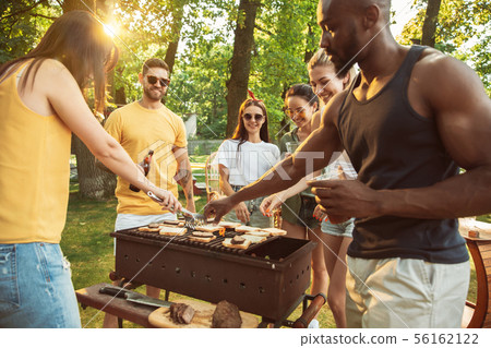 Happy friends are having beer and barbecue party at sunny day Happy friends are having beer and barbecue party at sunny day 56162122
