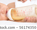 Sleeping newborn girl on bed in bedroom with 56174350