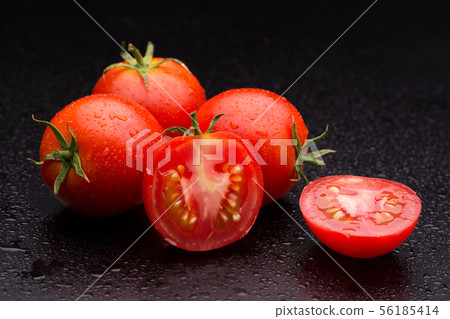 Sliced tomato on a dark background. Sliced tomato on a dark background. 56185414