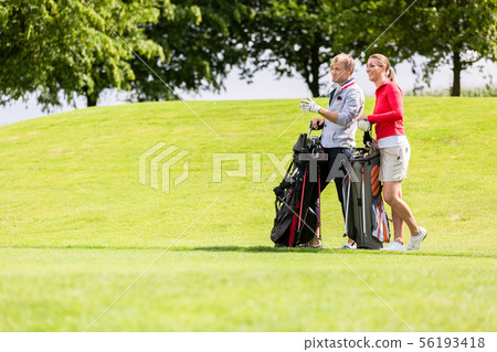 Golfing couple at golf field Golfing couple at golf field 56193418