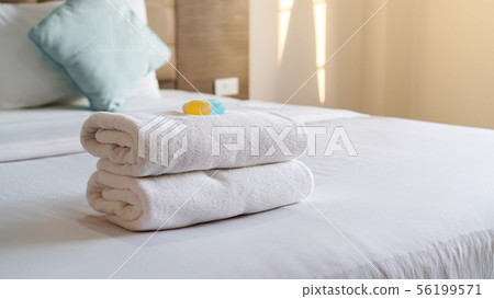 White towel shampoo and soap on a bed. 56199571