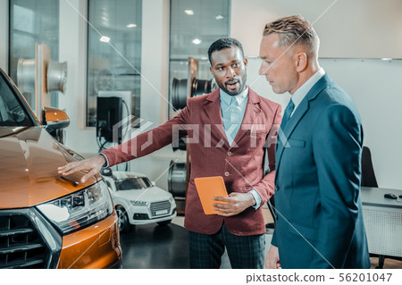 Car dealer helping his client buying a car. 56201047