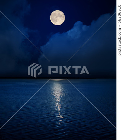 full moon in dark sky over clouds and water in 56206910