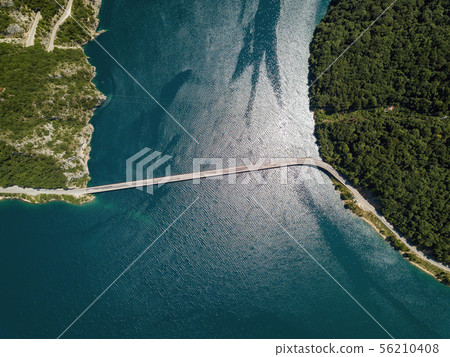 Aerial footage a car driving over a bridge on Piva Lake 56210408