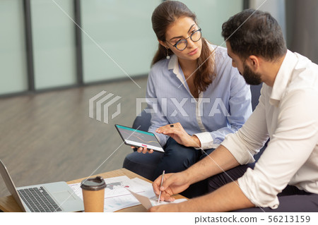 Attentive female person listening to her colleague 56213159