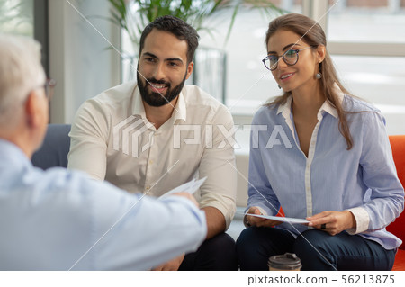 Cute longhaired female person sitting opposite her director Cute longhaired female person sitting opposite her director 56213875