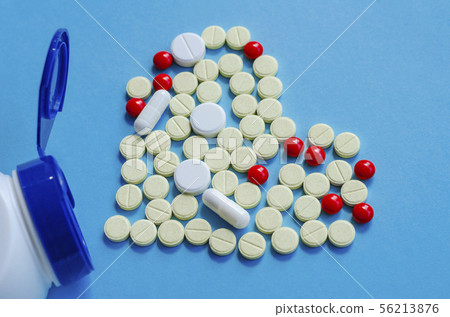 White heart pills on a colored background. White heart pills on a colored background. 56213876