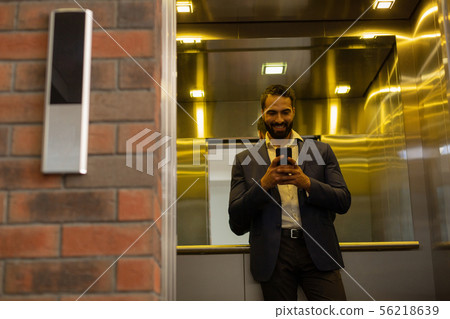 Cheerful young man staring at his telephone 56218639