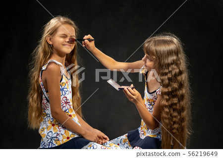 The girl closed her eyes when another girl powder 56219649