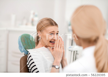 Dentists patient being happy having new braces. 56220395