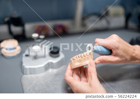 Dental technician preparing prosthesis for the patient. 56224224