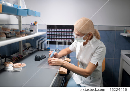 Dental technician making new dental prosthesis for the patient. 56224436