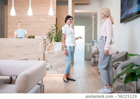 Dentist showing her patient where to go. 56225129