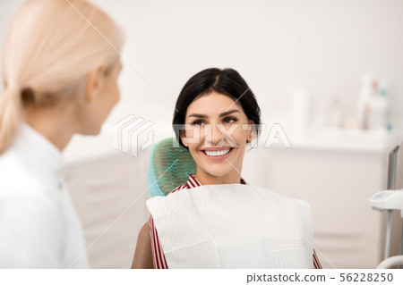 Woman being happy at her future teeth whitening. Woman being happy at her future teeth whitening. 56228250
