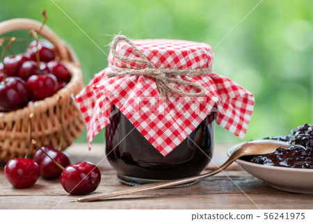 Jar of cherries jam, basket of cherries, saucer 56241975