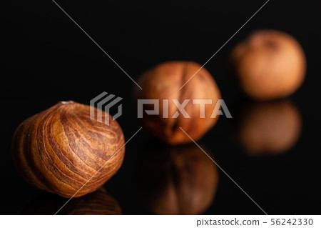Ripe brown hazelnut isolated on black glass 56242330