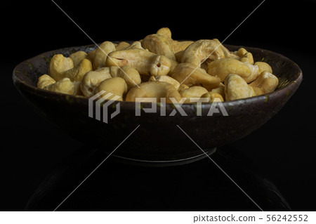 Raw unsalted cashew isolated on black glass 56242552