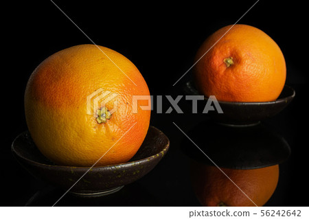 Fresh pink grapefruit isolated on black glass Fresh pink grapefruit isolated on black glass 56242642