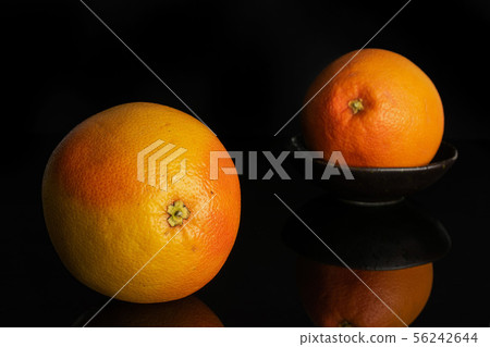 Fresh pink grapefruit isolated on black glass Fresh pink grapefruit isolated on black glass 56242644