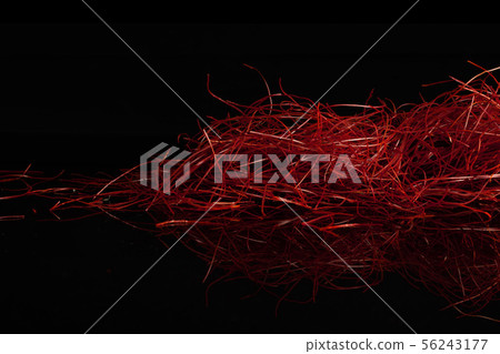 Red chili threads isolated on black glass 56243177