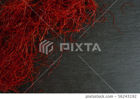 Red chili threads on grey stone 56243192