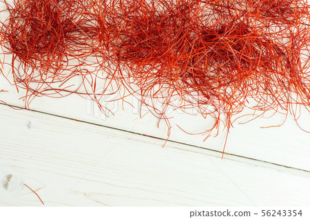 Red chili threads on grey wood 56243354
