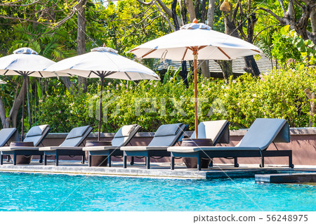 Beautiful landscape of sea ocean on sky with umbrella and chair around luxury outdoor swimming pool 56248975