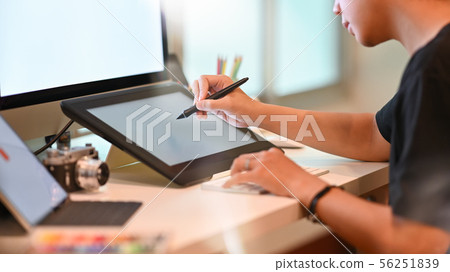 Young graphic designer working with pen and tablet Young graphic designer working with pen and tablet 56251839