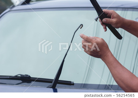 Mechanic replace windshield wipers on car. 56254565