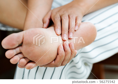 Woman massaging her painful barefoot 56275542