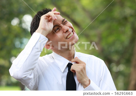 Male employee wiping sweat with hand 56291663