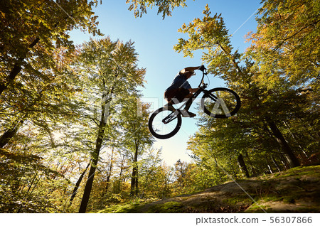 Professional sportsman cyclist jump on trial bike on boulder 56307866