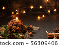 Christmas composition - decorative candle, Christmas tree branches and decorations on a dark 56309406