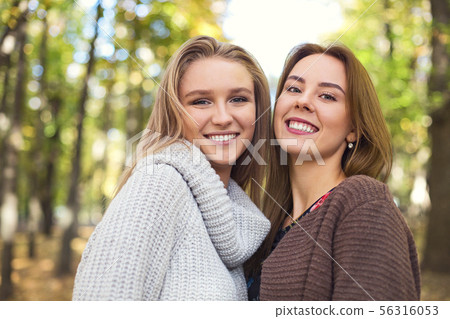 Fashionable beautiful young girlfriends walking Fashionable beautiful young girlfriends walking 56316053