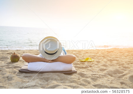 Man in the hat with coconut cocktail on the beach 56328575
