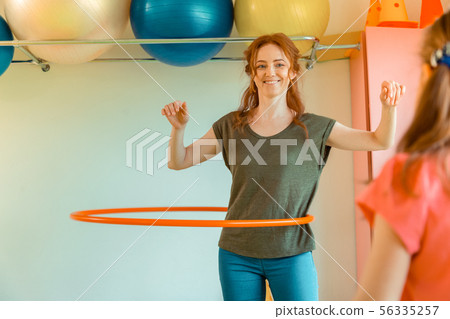 Happy positive woman rotating a hula hoop 56335257
