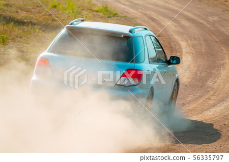 Rear View of a Blue Car on a Dusty Road 56335797