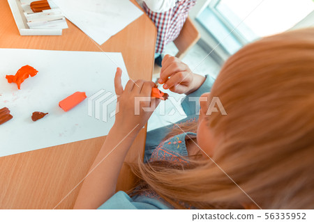 Top view of a pleasant cute girl creating her artwork Top view of a pleasant cute girl creating her artwork 56335952