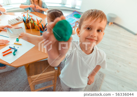 Joyful happy boy showing you a plastic piece 56336044