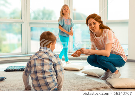 Pleasant friendly woman smiling to the child Pleasant friendly woman smiling to the child 56343767