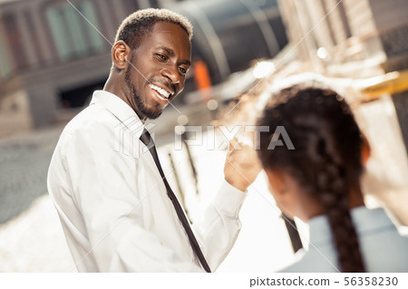 Positive delighted dark-skinned man talking to his kid 56358230